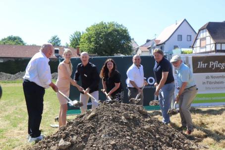 Hartmut und Chantal Ostermann (Geschäftsführung der Victor’s Group), Jens Hertzer (Geschäftsführung exsos GmbH), Pfarrerin Ingeborg Beiersdorf, Ortsbürgermeister Tobias Rohrwick, Landrat Heiko Sippel sowie VG-Beigeordneter Michael Röhrenbeck (v. l. n. r.) beim offiziellen Spatenstich für das neue Seniorenwohnprojekt in der Philipp-Merkel-Straße in Flörsheim-Dalsheim. (Foto: Exsos GmbH)